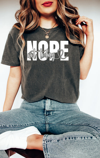 a woman sitting on a stool wearing a shirt that says nope