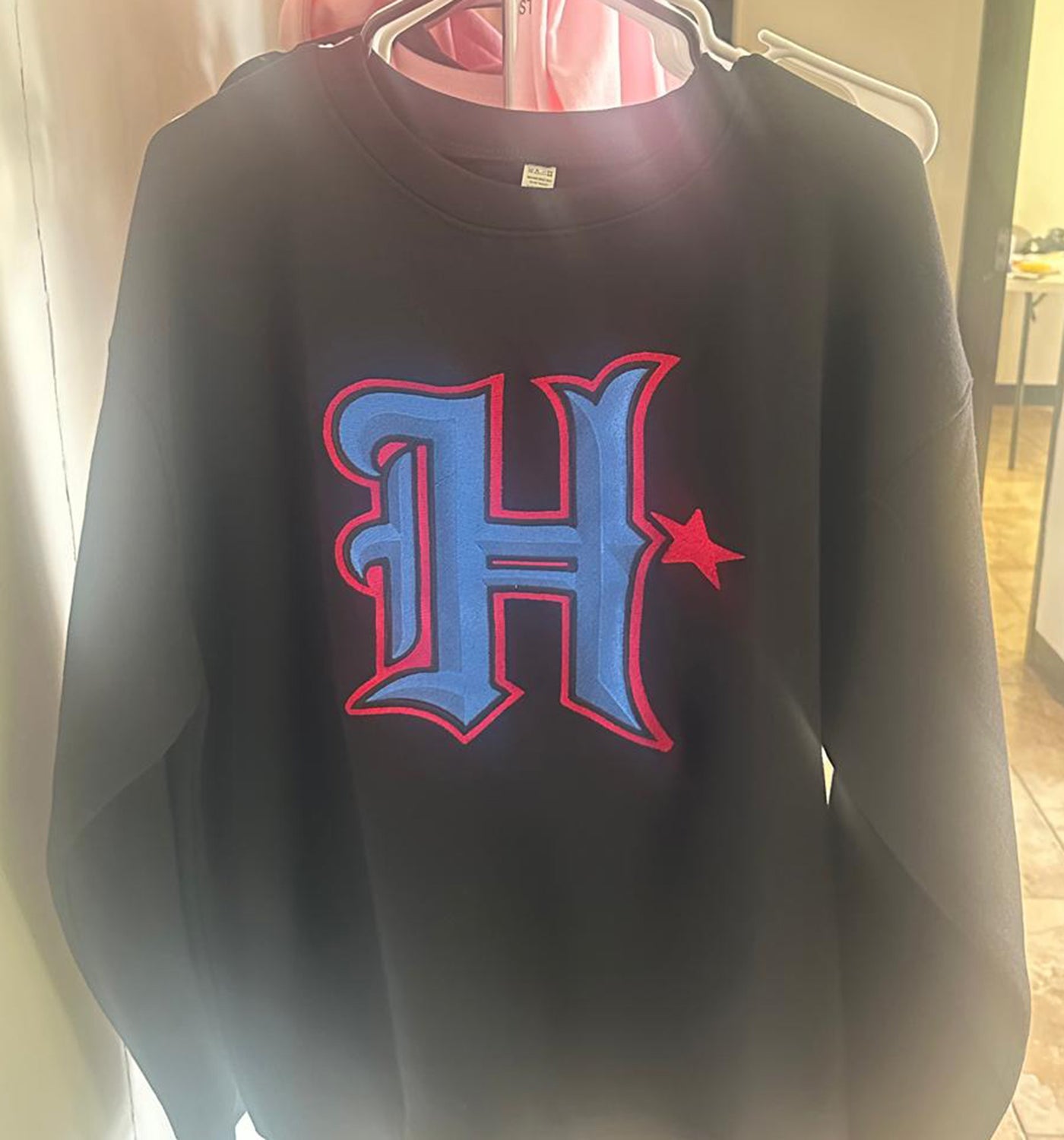 a black shirt with a red and blue h on it