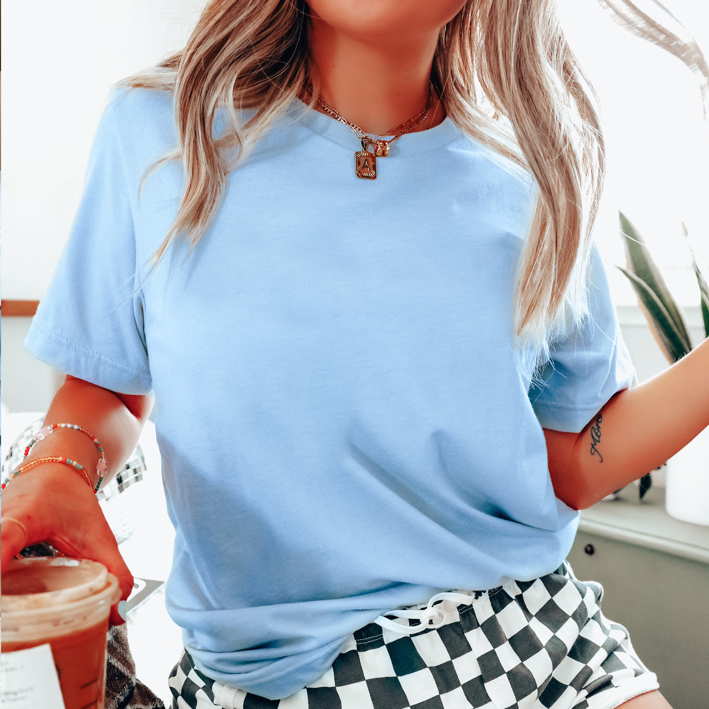 a woman wearing a blue shirt and checkered shorts