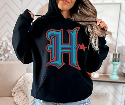 a woman wearing a black hoodie with the letter h on it