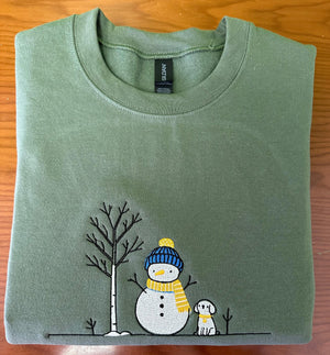 embroidered  a green shirt with a snowman and a dog on it